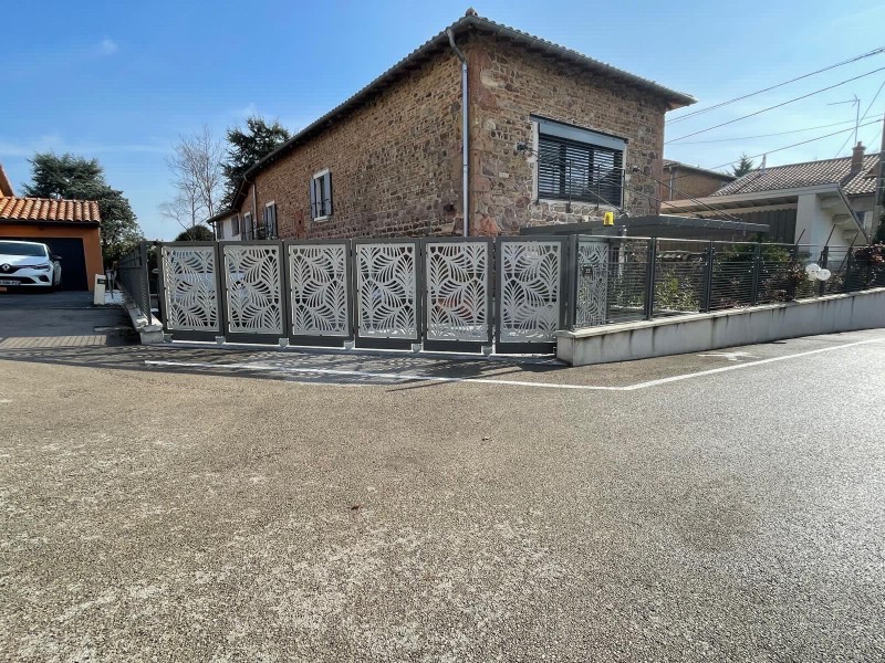 Création et installation d’un portail sectionné coulissant sur mesure dans le Beaujolais: une intégration parfaite pour une propriété élégante.