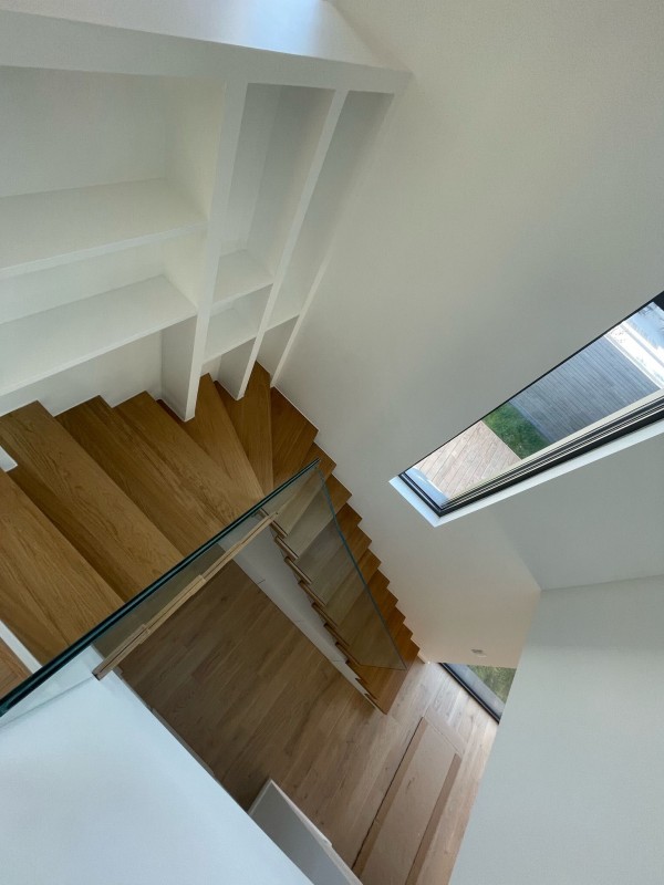 Un escalier autoportant unique à Charbonnières-les-Bains : chêne massif, métal et verre pour un design intégré et fonctionnel dans votre intérieur